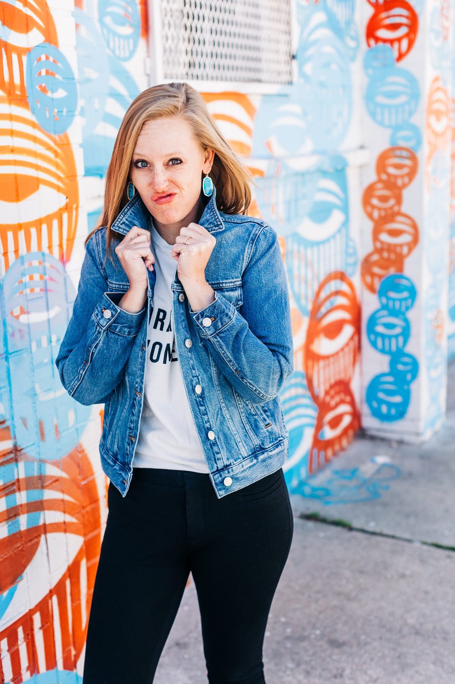 Christi Loucks in a denim jacket in front of a mural