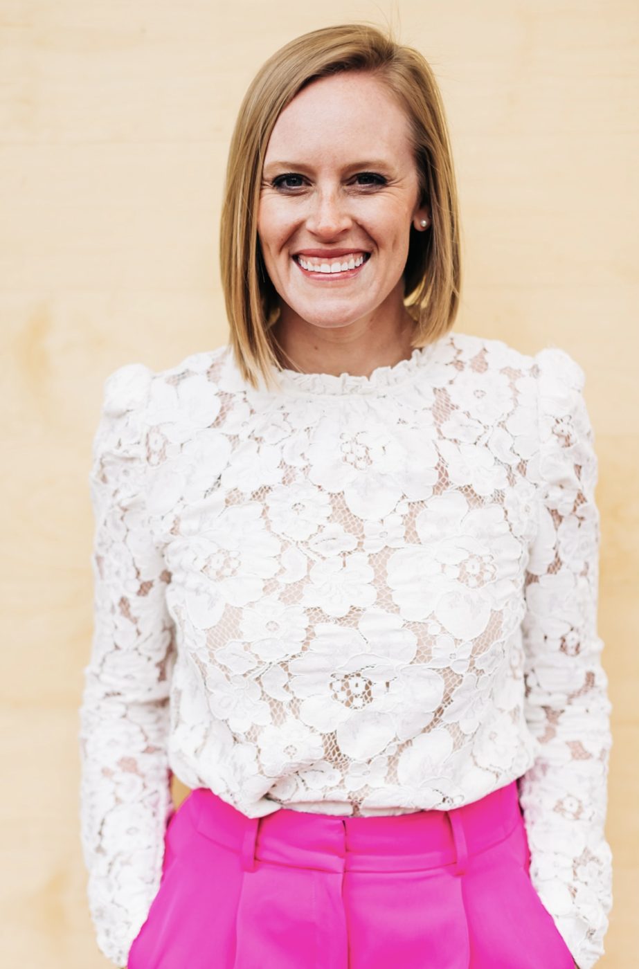 Christi Loucks in a white lace top and pink pants